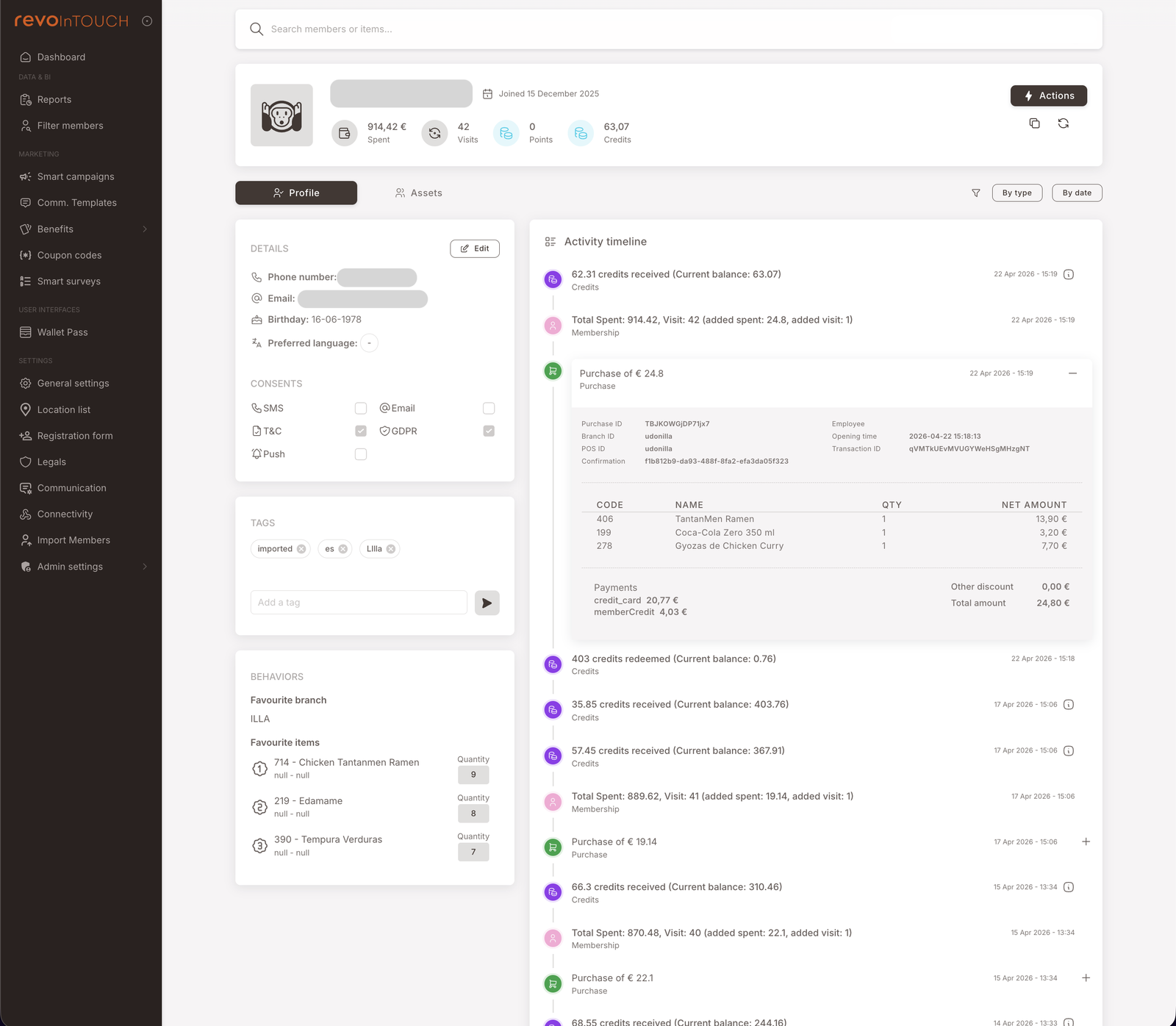 A full member profile page. Top: avatar, masked member ID, joined date "15 December 2025", and four stat tiles — 914.42 € Spent, 42 Visits, 0 Points, 63.07 Credits. Tabs: Profile (selected) / Assets. Top-right: Actions button. Profile tab left side, top to bottom: Details panel (Phone number, Email, Birthday, Preferred language with an Edit button); Consents panel (SMS / Email / T&amp;C / GDPR / Push checkboxes); Tags panel (chips: imported / es / Lila with an Add a tag input); Behaviors panel (Favourite branch: ILLA; Favourite items: 714 Chicken Tandameen Ramen, 278 Edamame, 300 Tempura Verduras with quantity counts). Right side: Activity timeline header with By type / By date sort, then a long chronological list of events — Credits received, Total Spent updates, Membership events, Purchases (with one Purchase expanded to show line items: Tampakaen Ramen 13.50€, Coca-Cola Zero 200ml 2.20€, Spagas de Chicken-Curry 7.70€, Other discount 0.00€, Total amount 24.40€, Payment credit_card 19.77€ memberCredit 4.93€).