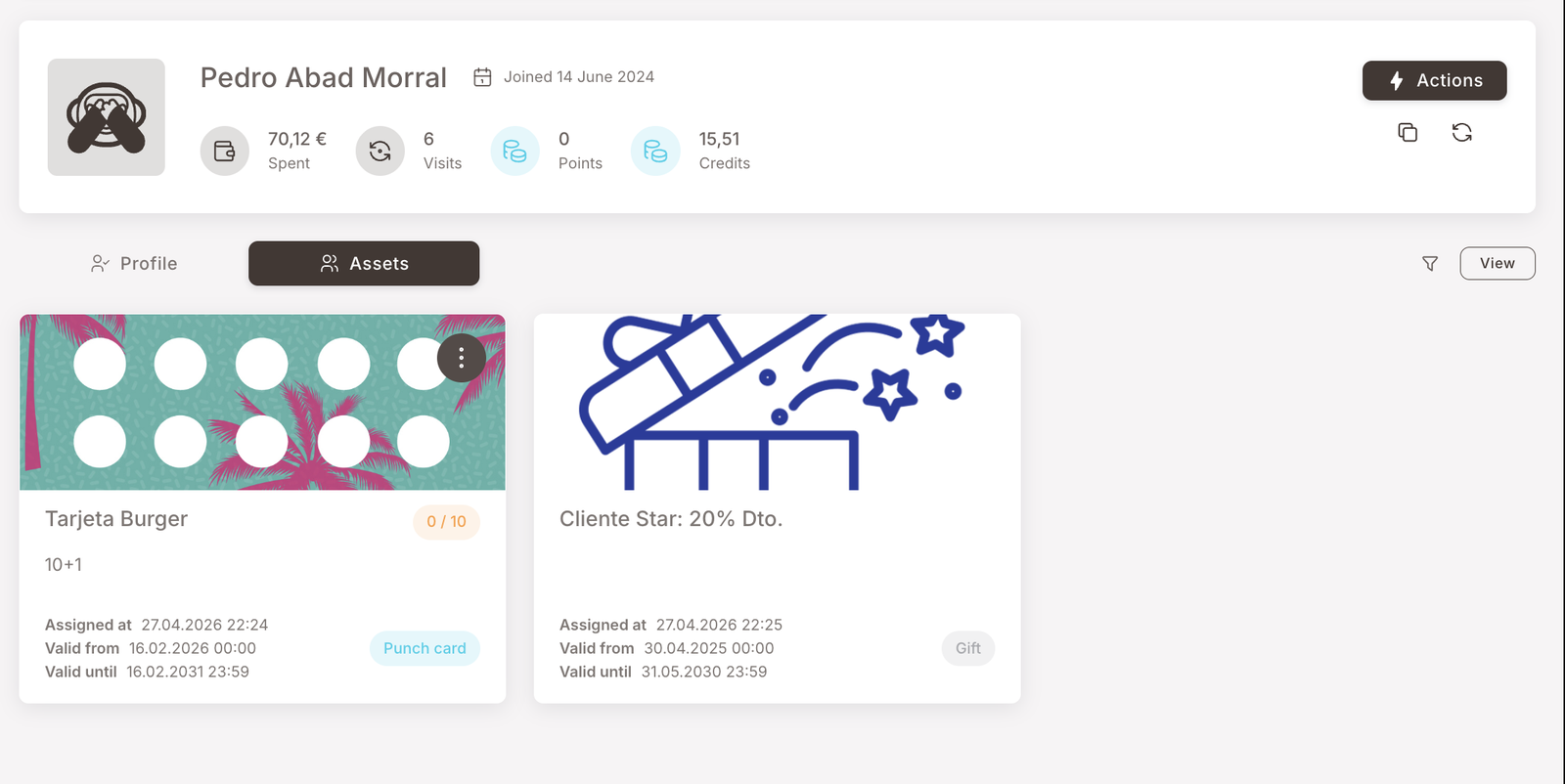 Member profile with the Assets tab selected. Two asset cards visible: a Punch card "Tarjeta Burger" (10+1, polka-dot card artwork) showing 0/10 punches, assigned 27.04.2026, valid until 16.02.2030; and a Gift "Cliente Star: 20% Dto." (illustrated rocket artwork) assigned 27.04.2026, valid until 31.05.2030. Each card has a View button on the right.